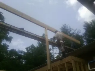 Carpenter setting a ridge beam over a new addition frame — Ice Dam Removal by Roofing Brothers in Schererville