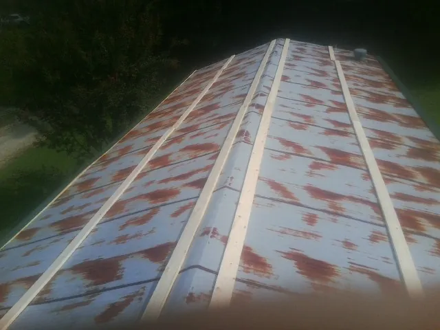 Rusted metal roof panels with new wood purlins before replacement — Storm Damage Roof Repair in Schererville by Roofing Brothers