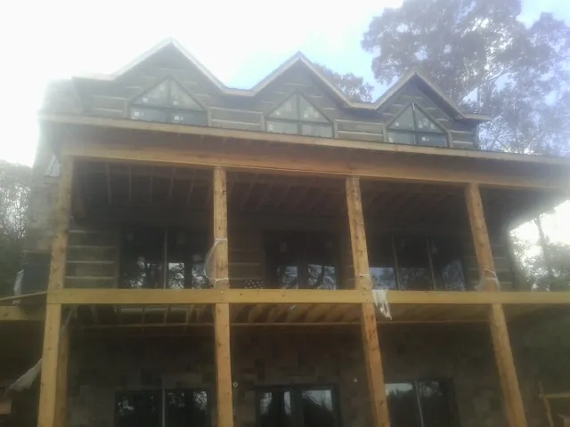 Dormers and porch framing on a large log home under construction — Roof Coating work by our crew in Schererville