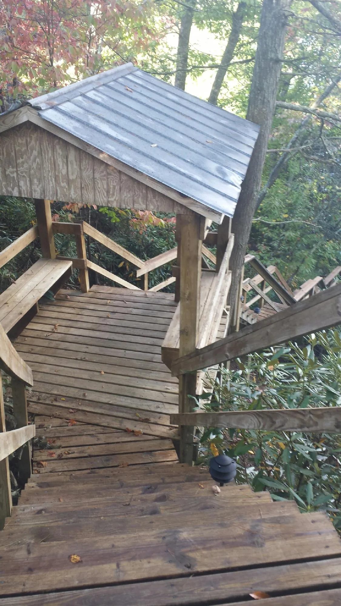 Metal roofed shelter over wooden steps on a wooded walkway — Skylight Repair & Installation work by our crew in Schererville