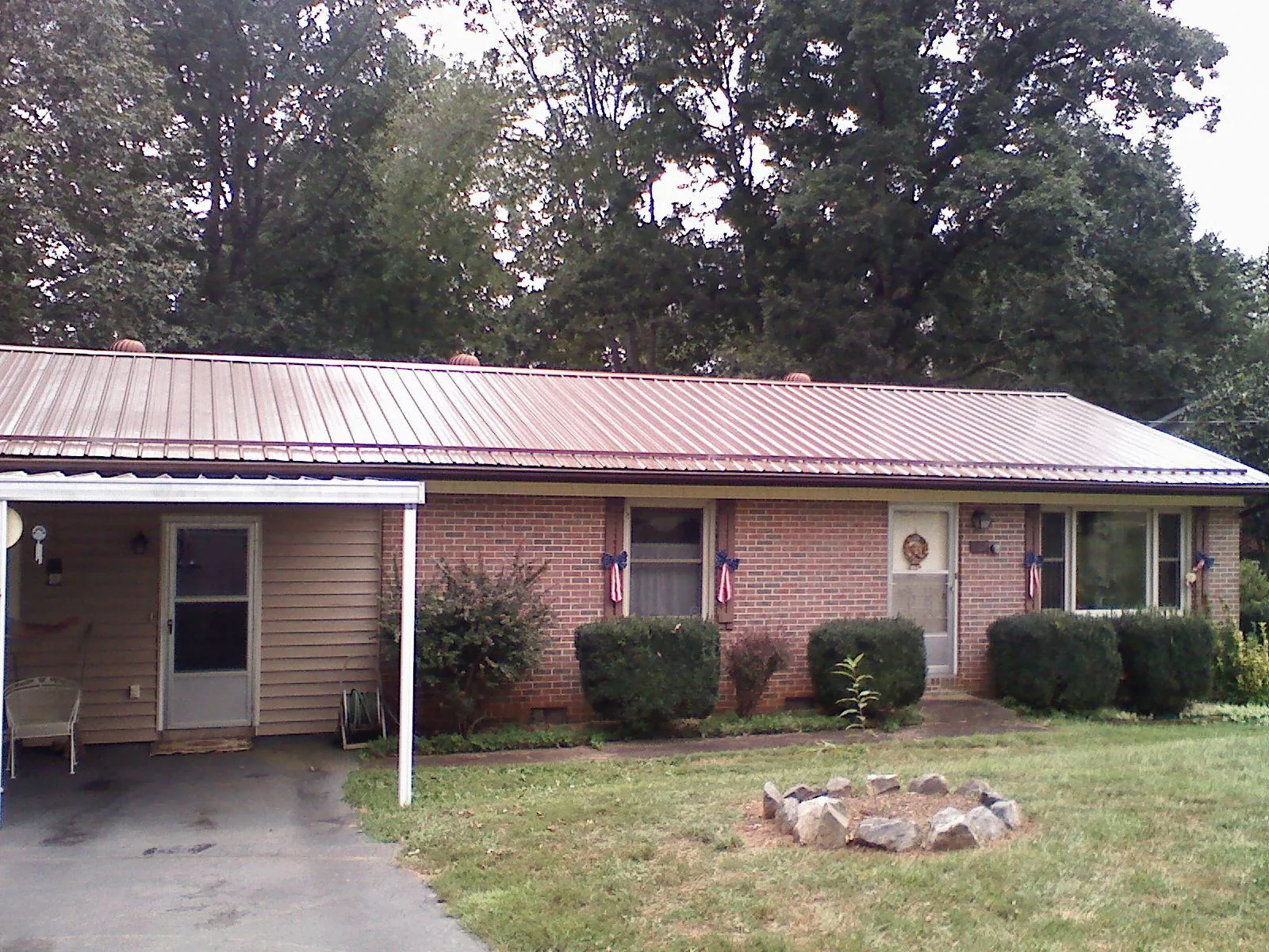 Bronze metal roof and carport on a brick ranch home — Roof Repair work by our crew in Schererville